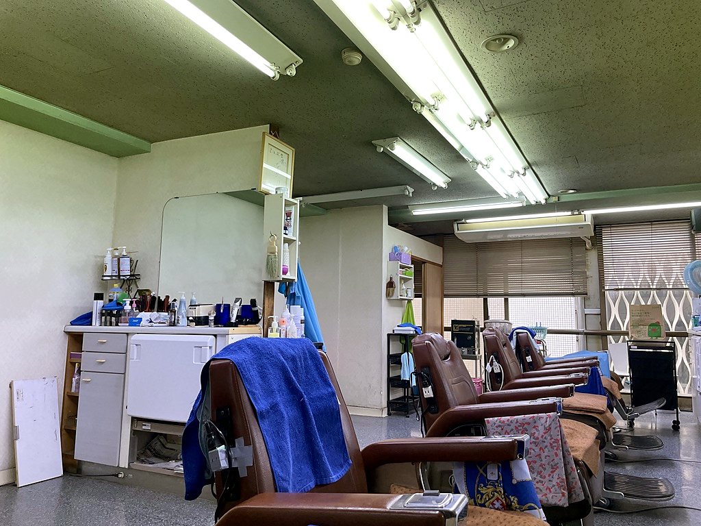 窓の側に理容椅子が並ぶ店内